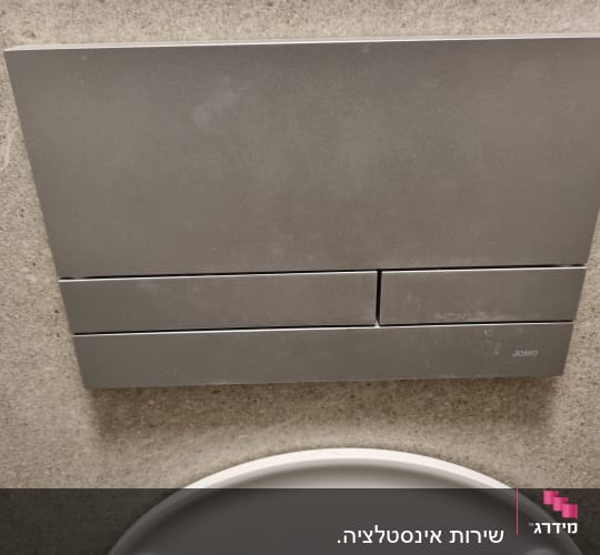 לחצן הדחה לאסלה על קיר אמבטיה
